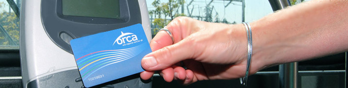 hand putting orca card in front of reader